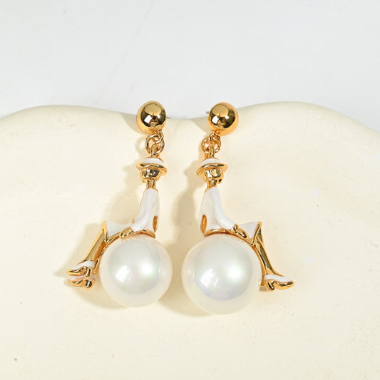 Close-up detail of ballerina figural earring with pearl drop, vintage whimsical gold jewelry styled shot