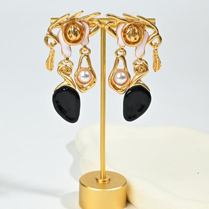 Detail shot of asymmetric resin drop earring with baroque gold crown motif and dark resin embellishment