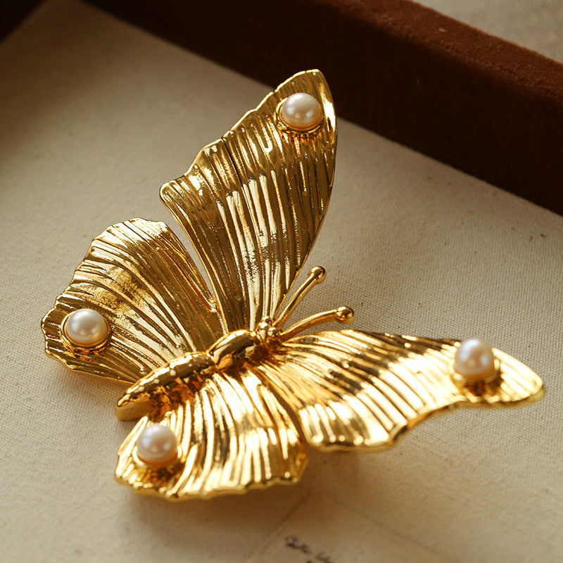 Side view of the 3D gold butterfly brooch, highlighting the elegant curvature and the multi-dimensional design of the layered wings.