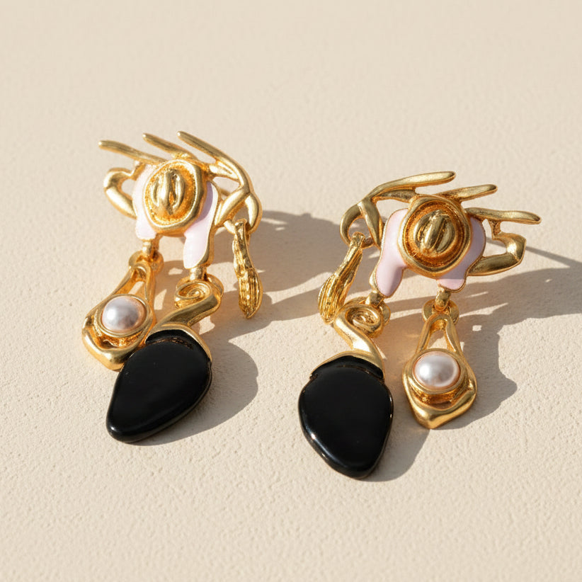 Close-up detail of baroque crown earring showing intricate gold metalwork and midnight black resin drop