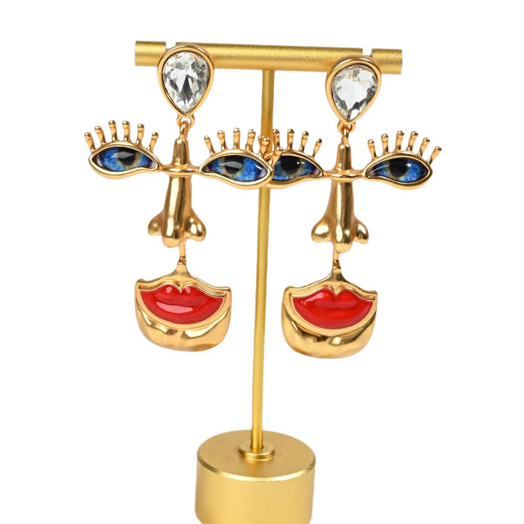 Anatomical eye stud earrings in 18K gold plated finish, surrealist statement jewelry on white background