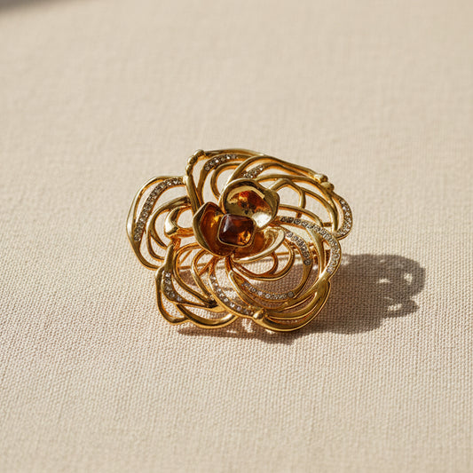Vintage hollow-out camellia flower brooch in 18k gold plating with crystal accents.