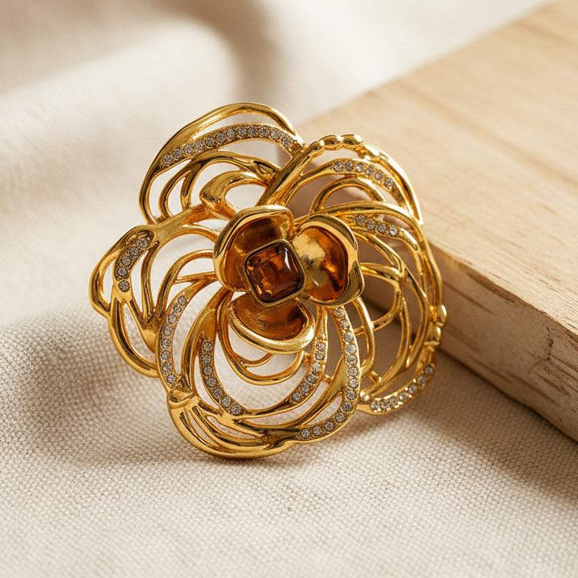 Detailed filigree gold camellia pin showing premium craftsmanship and texture.