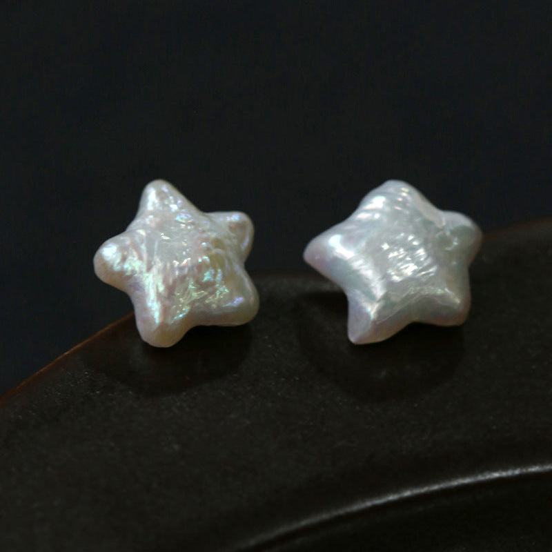 Celestial star-shaped baroque freshwater pearl stud earrings in silver, minimalist dainty jewelry for women, flat lay product photo

