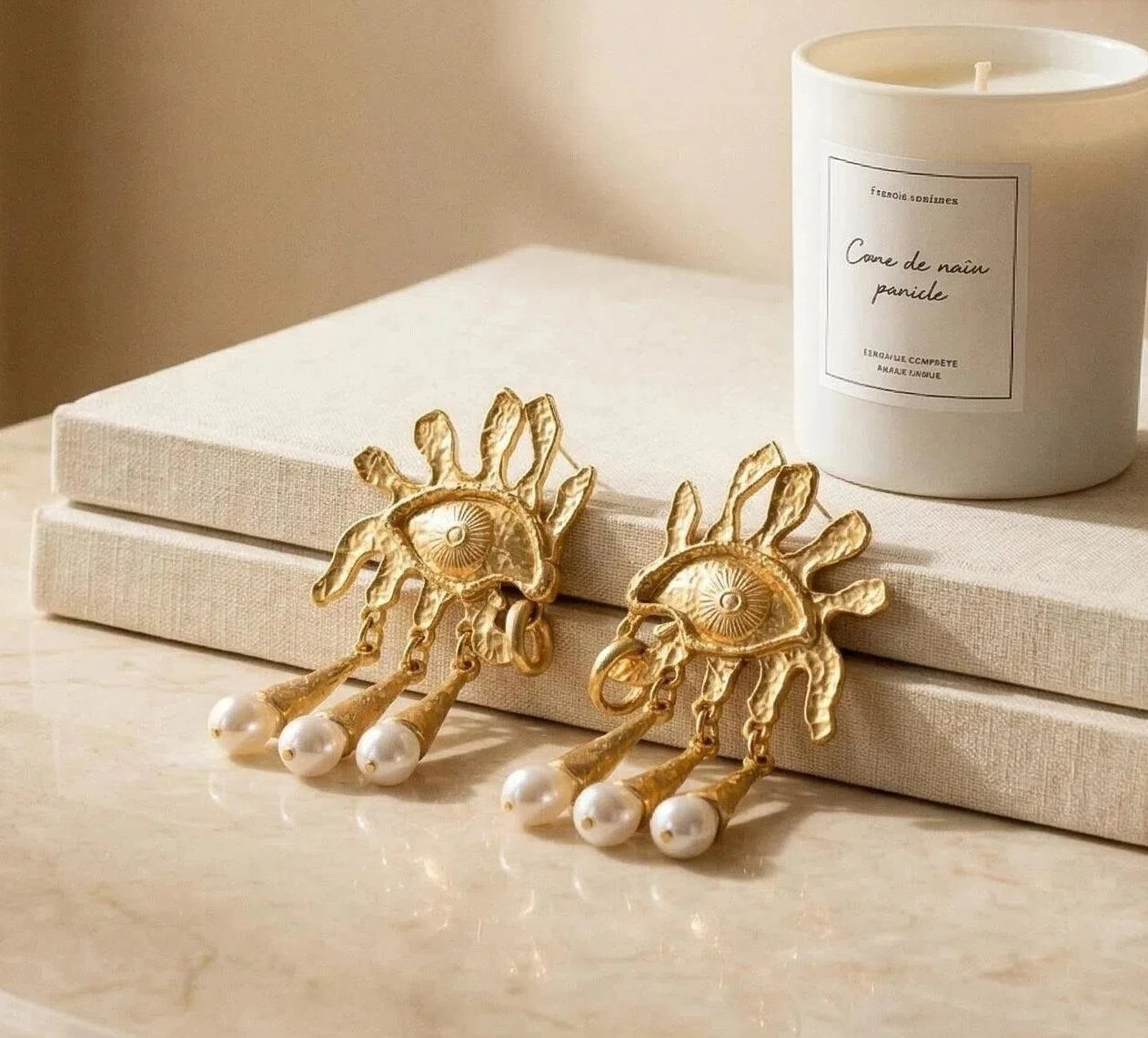 Pegasus Ascent earrings styled in studio setting, celestial moon and heart drop design, antique gold finish