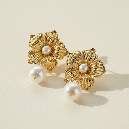 Vintage-style detailed gold filigree flower and pearl stud earrings.