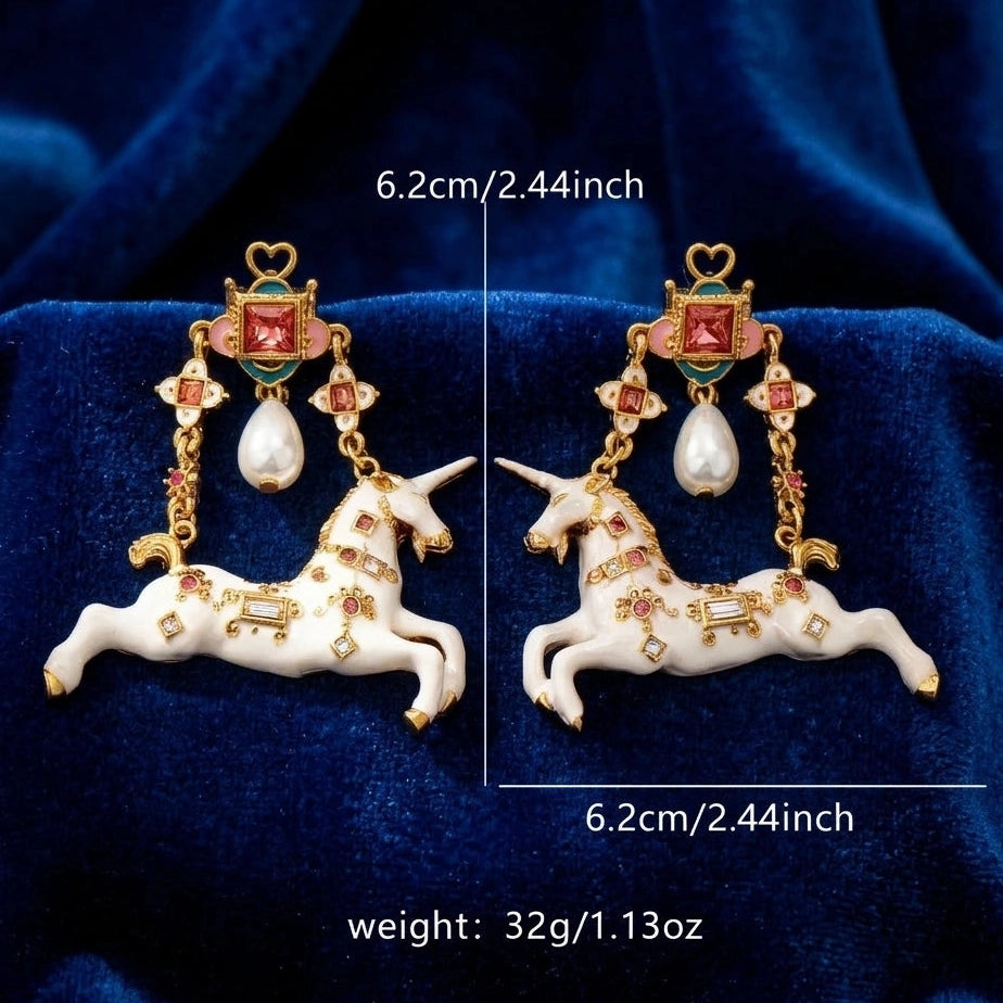 Surrealist Unicorn Dangle Earrings size reference on blue velvet background, showing full length