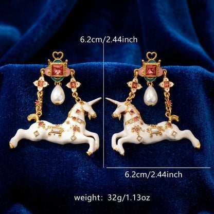 Surrealist Unicorn Dangle Earrings size reference on blue velvet background, showing full length