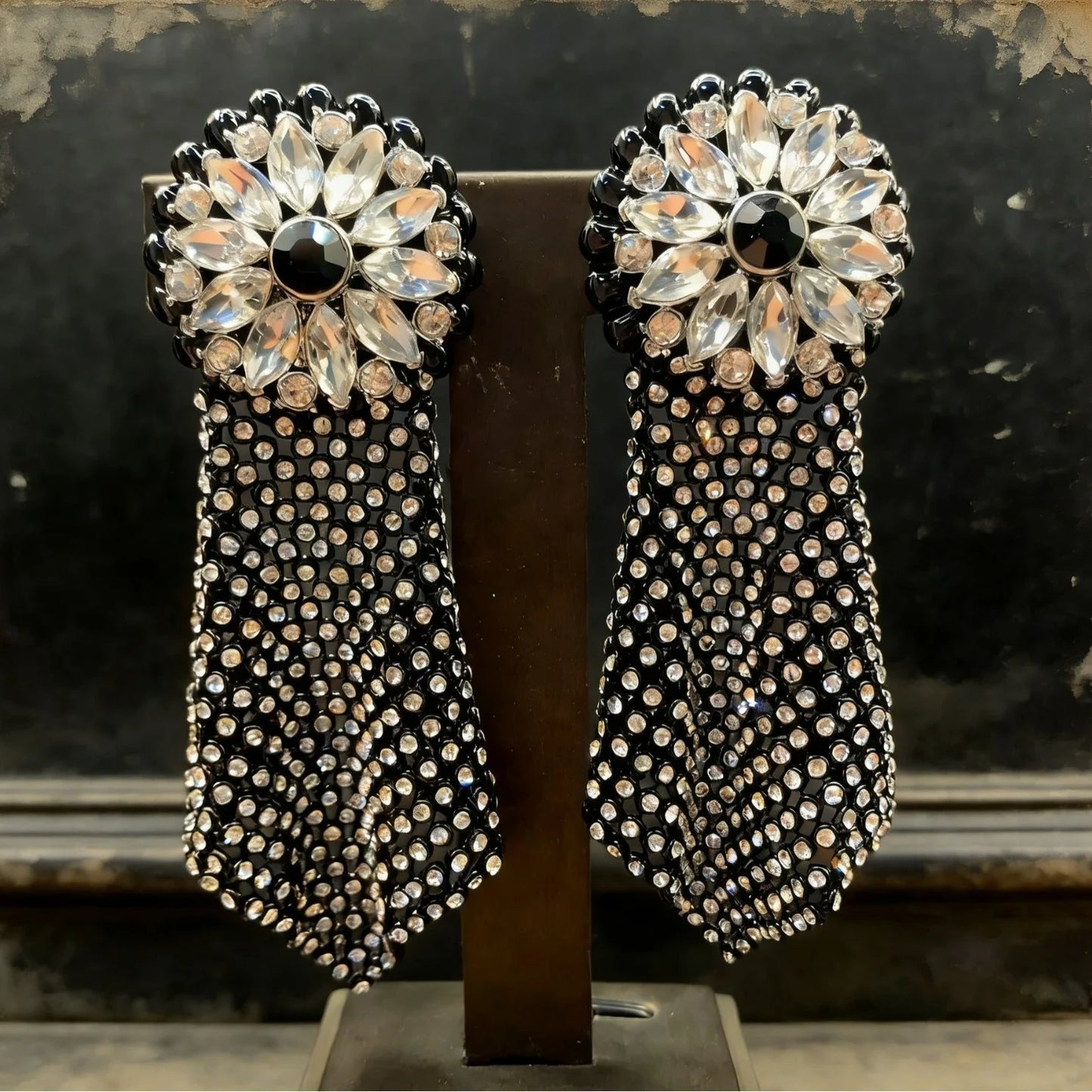 Detail shot of crystal tassel drop earring with intricate vintage mesh and midnight dark crystal accents