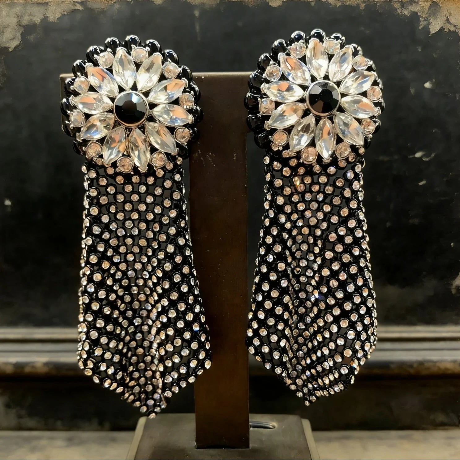 Detail shot of crystal tassel drop earring with intricate vintage mesh and midnight dark crystal accents