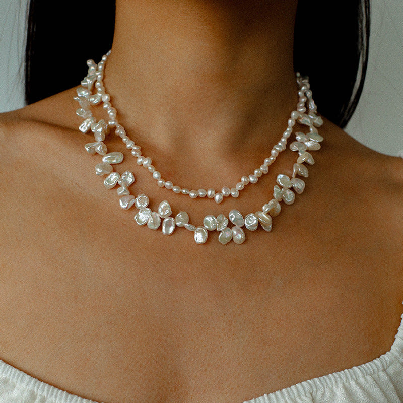 Lifestyle shot of a model wearing the layered petal pearl necklace, demonstrating how the double-strand design creates a sophisticated, bohemian look.