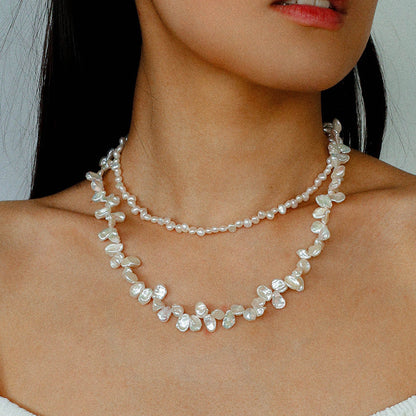 A model showcasing the natural luster and textured surface of the irregular pearl strands, emphasizing the jewelry's artistic and organic aesthetic.
