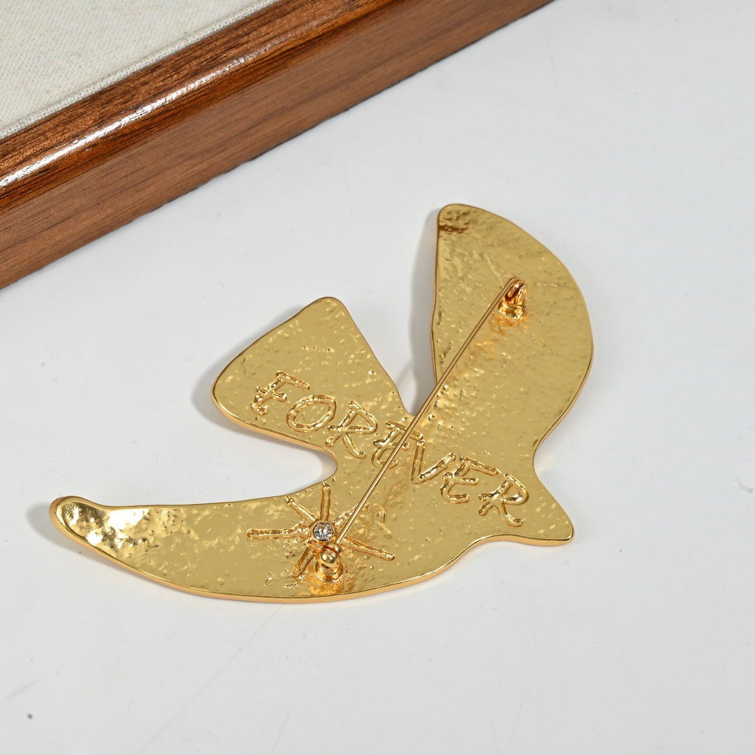 Reverse side of Golden Echoes peace dove brooch showing pin clasp mechanism and hammered brass construction
