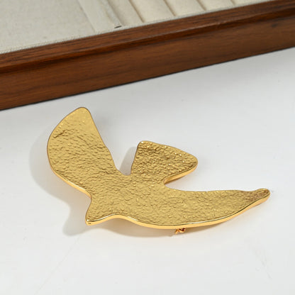 Close-up front detail of Golden Echoes hammered brass dove brooch, 18K gold plated surrealist statement piece by The Civilis