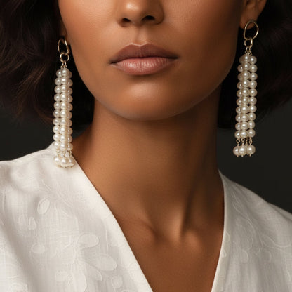 Close-up of the cascading pearl tassel earrings worn with a white V-neck top, highlighting how they elongate the neck and add a touch of luxury.