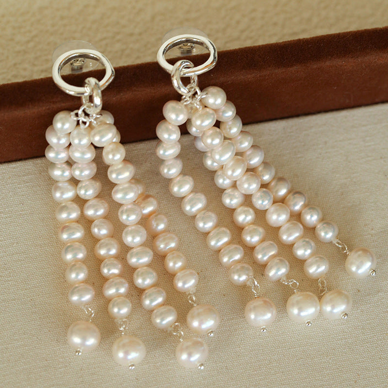 Detailed view of the multi-layered pearl strands and silver ring top, highlighting the exquisite craftsmanship and the luster of each individual pearl.