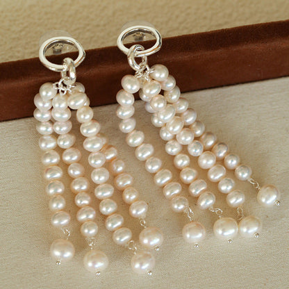 Detailed view of the multi-layered pearl strands and silver ring top, highlighting the exquisite craftsmanship and the luster of each individual pearl.