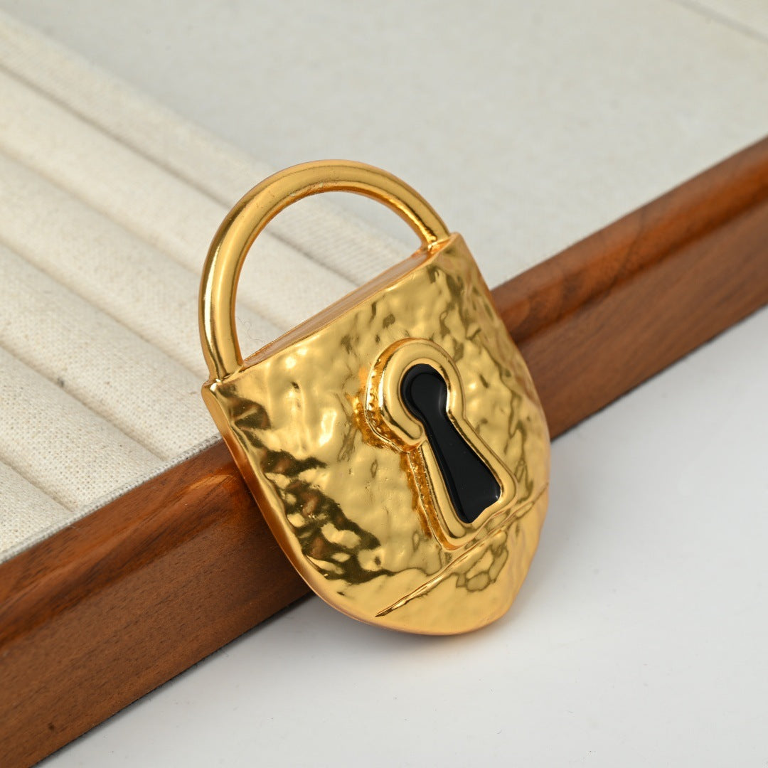 Close-up of surrealist brass lock brooch showing intricate gold plated metalwork and decorative details

