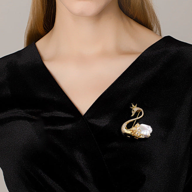 Elegant Woman Wearing a Swan Baroque Pearl Brooch on a Black V-neck Silk Dress.