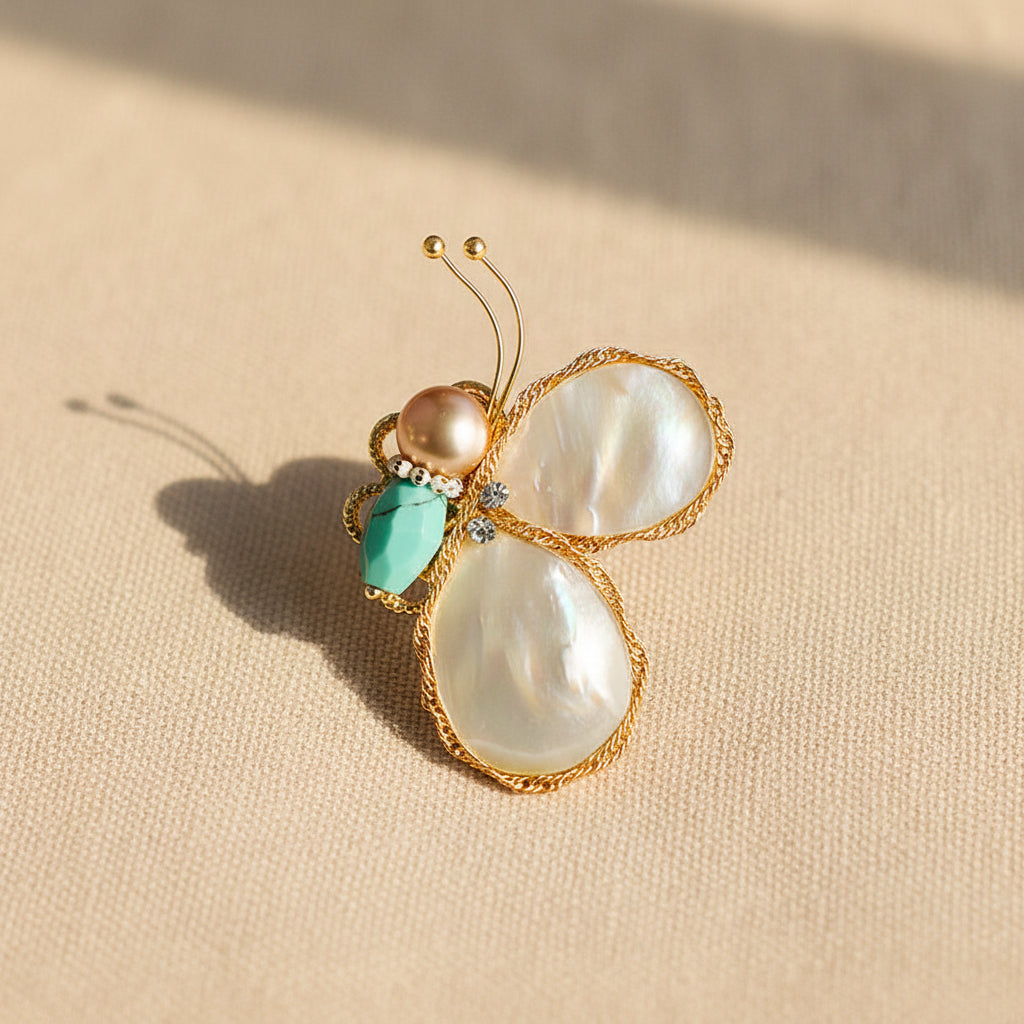 Lustrous Natural Pearl Butterfly Pin Glowing in Warm Sunlight on Beige Linen.
