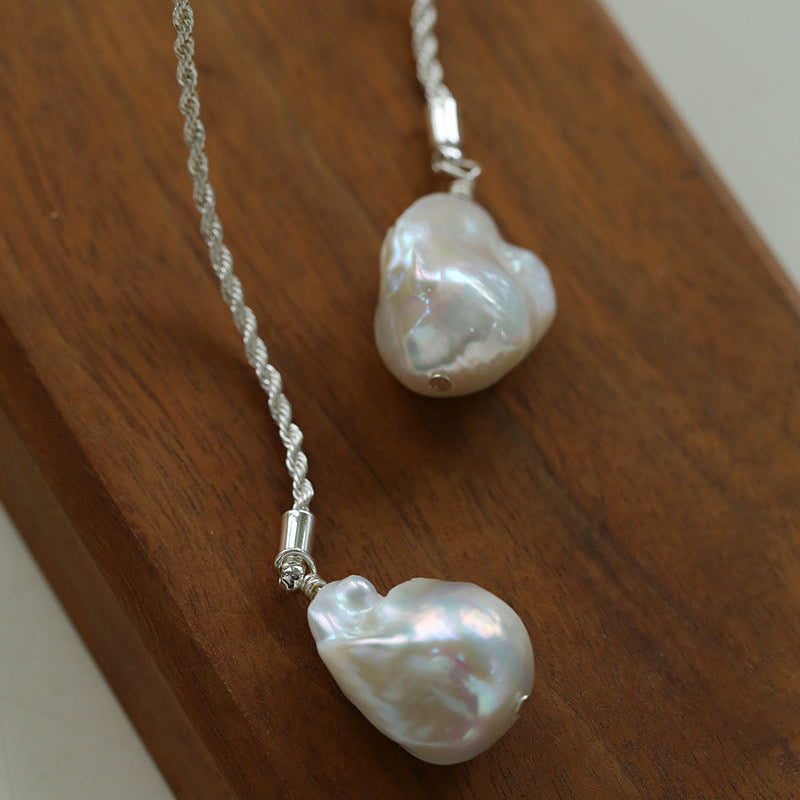 Close-up detail of silver baroque pearl lariat necklace twisted rope chain texture freshwater pearl pendant

