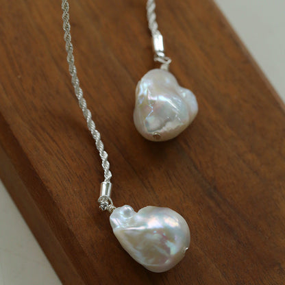 Close-up detail of silver baroque pearl lariat necklace twisted rope chain texture freshwater pearl pendant

