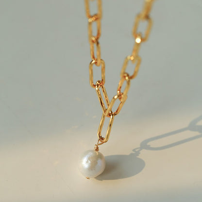 Detail shot of 18K gold plated paperclip chain necklace baroque pearl pendant minimalist statement jewelry


