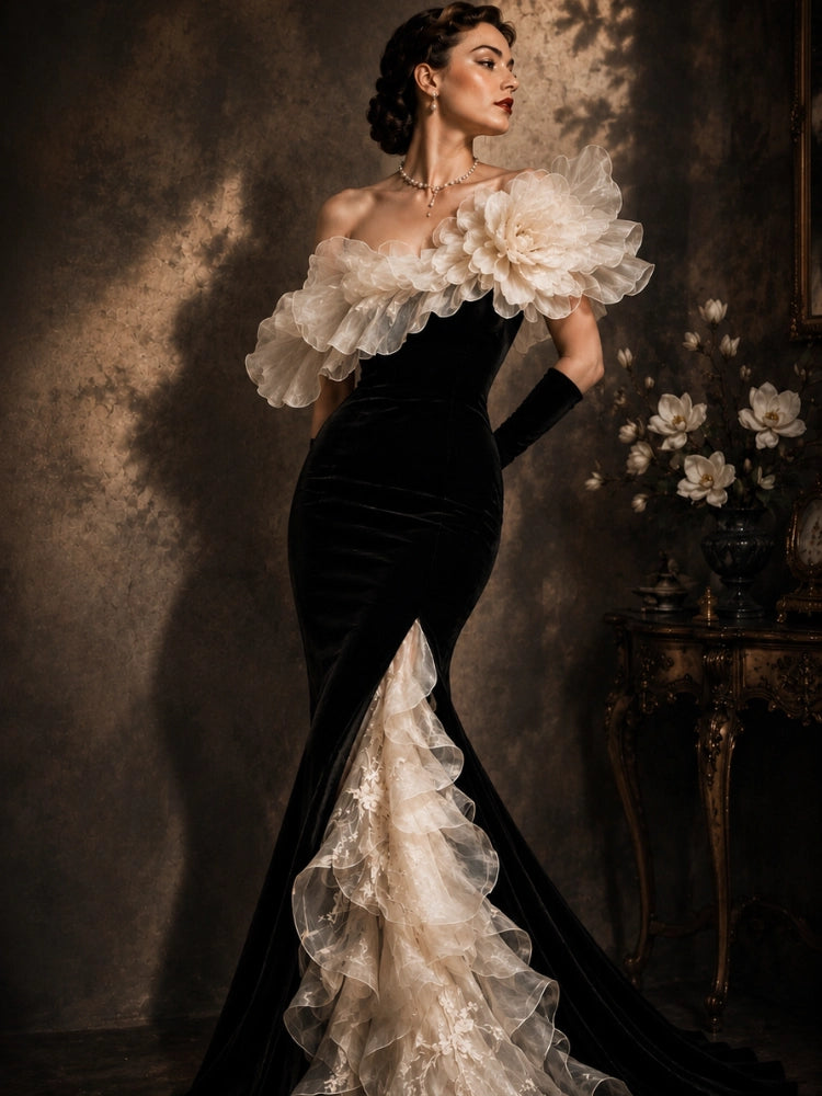 Elegant mobile slideshow banner for The Civilis, featuring a model in a sophisticated black strapless column dress adorned with dramatic white ruffled flowers and a cascading tiered mermaid hemline, next to a vintage vanity table.